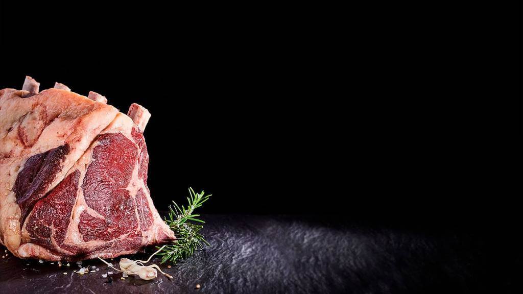 Chuletón de vacuno con romero sobre una superficie de piedra